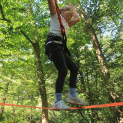 Mädchen balanciert auf einer Slackline.